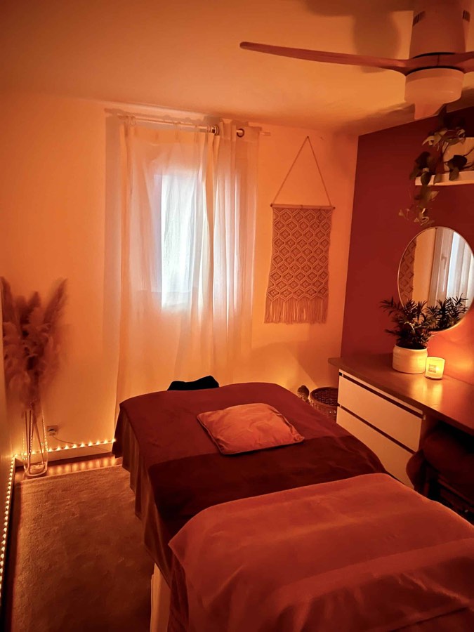 La table de massage préparée devant la fenêtre voilée du salon